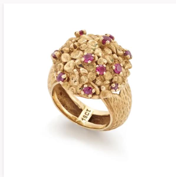 A ruby set cluster ring, the circular nugget style head with scattered claw set rubies